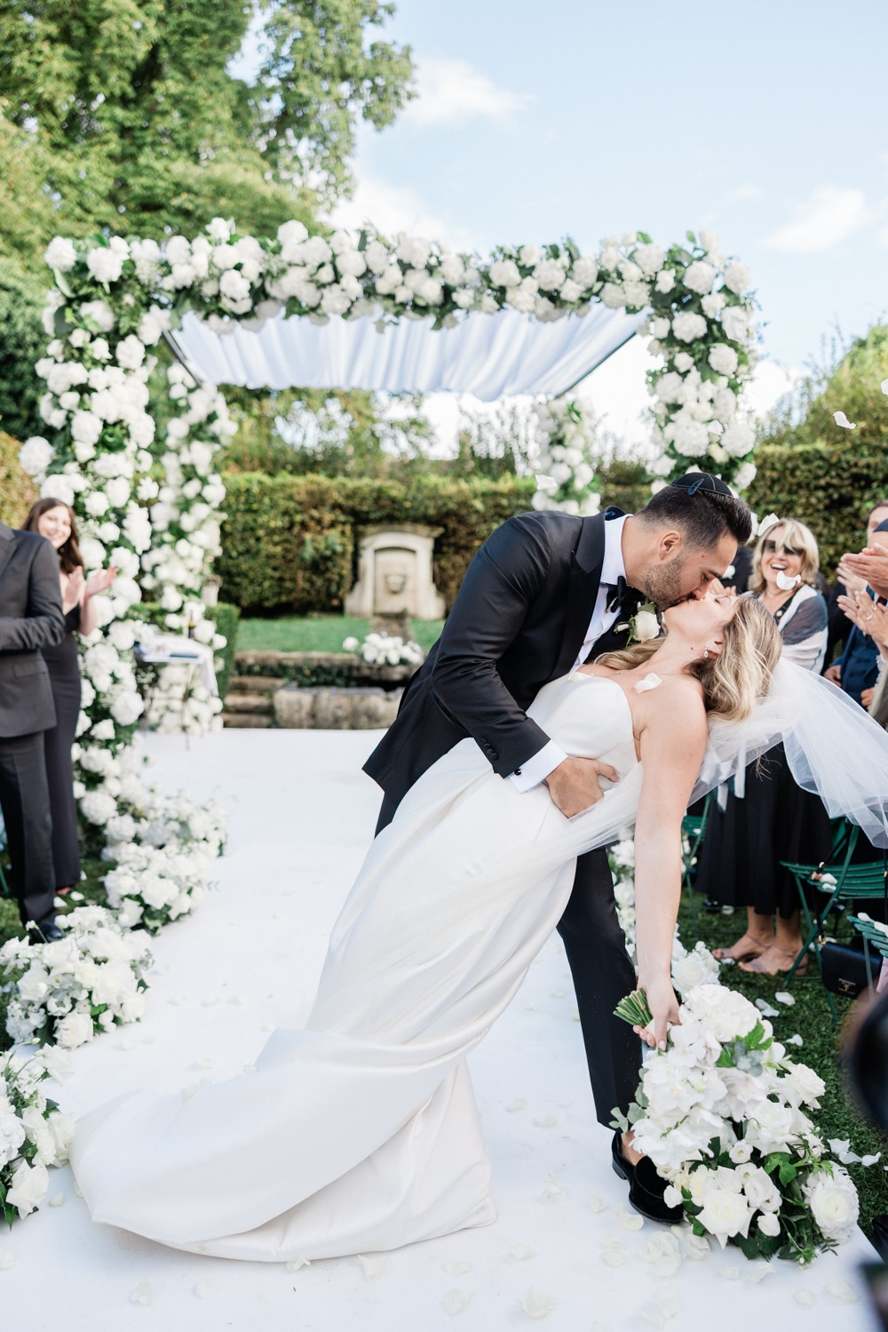 Just married couple sharing a deep kiss after the ceremony