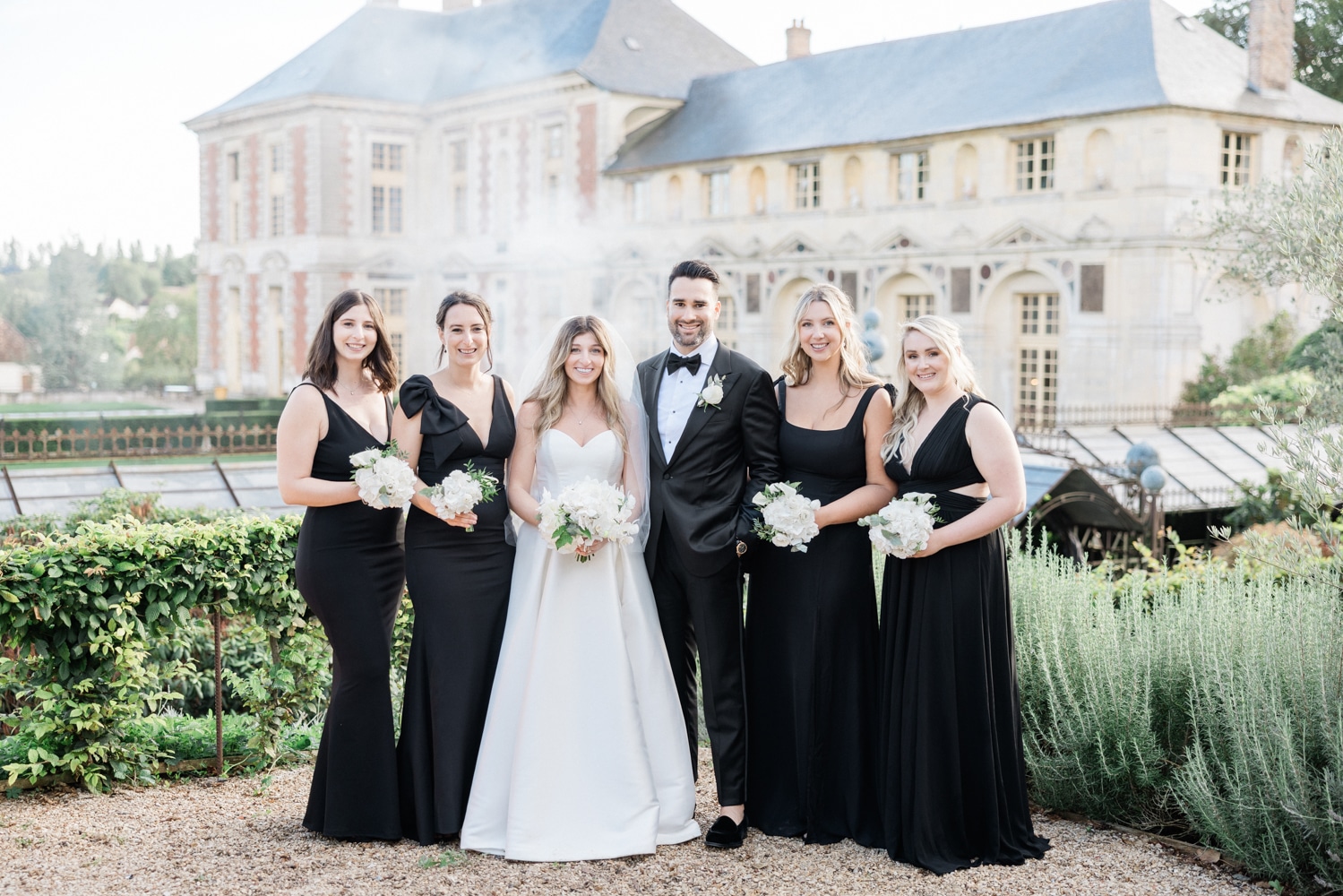 Elegant bridal party photo in front of the historic Château de Vallery