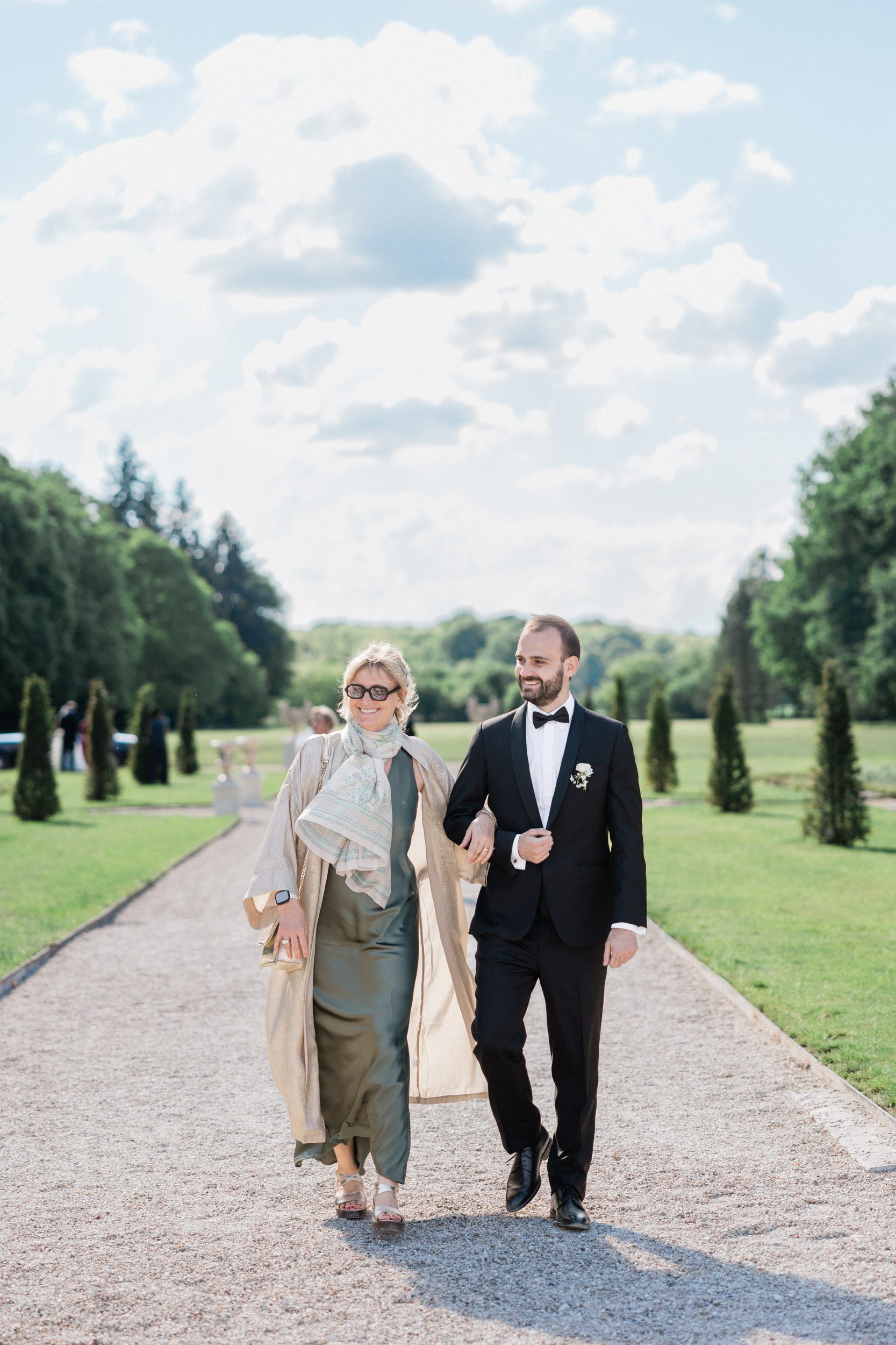 Groom and his mother walking down the aisle during her wedding ceremony at Château de Nainville-les-Roches