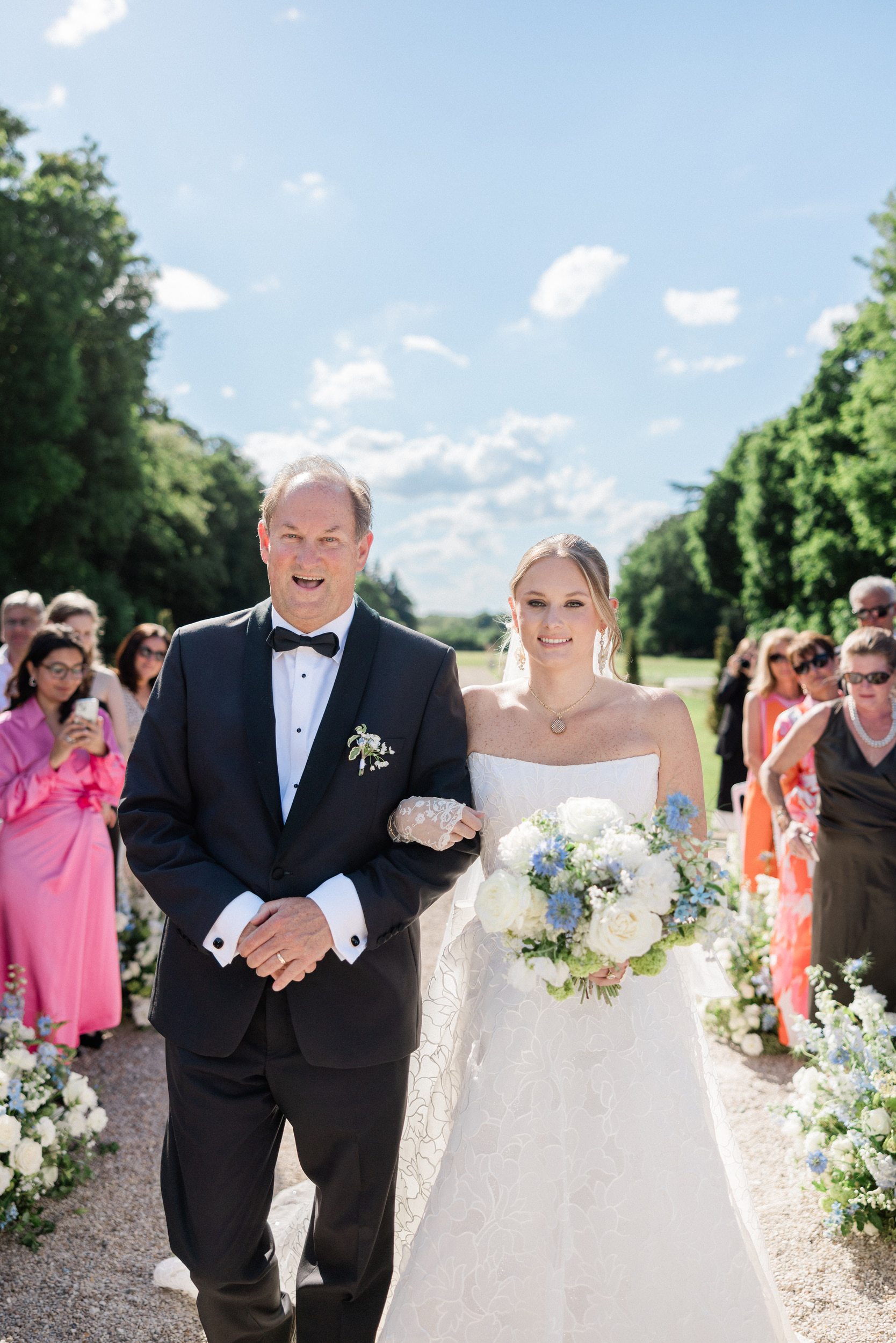 Bride and her father walking down the aisle during her wedding ceremony at Château de Nainville-les-Roches