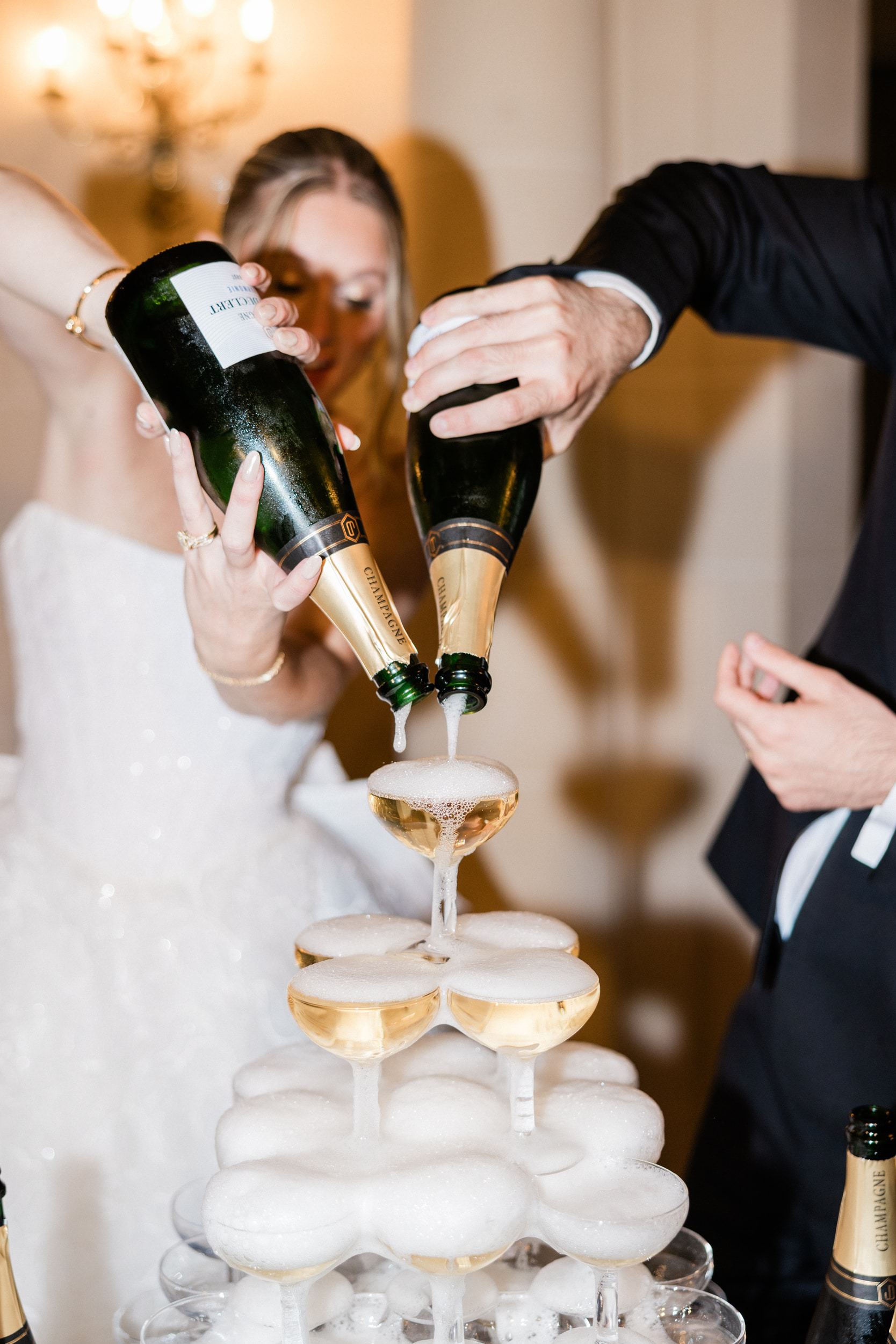 Bride and groom enjoying a champagne tower during their wedding reception